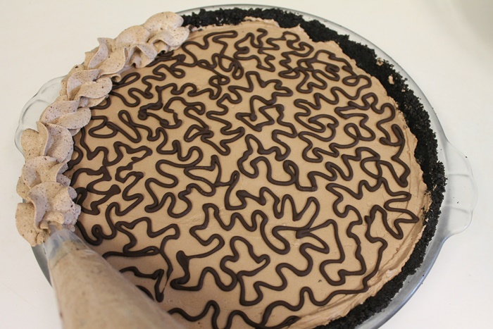 no bake Chocolate Cheesecake Pie with chocolate whipped cream around edge